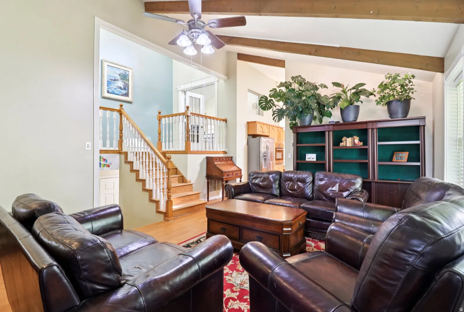 Living area with a ceiling fan, lofted ceiling, and wood finished floors