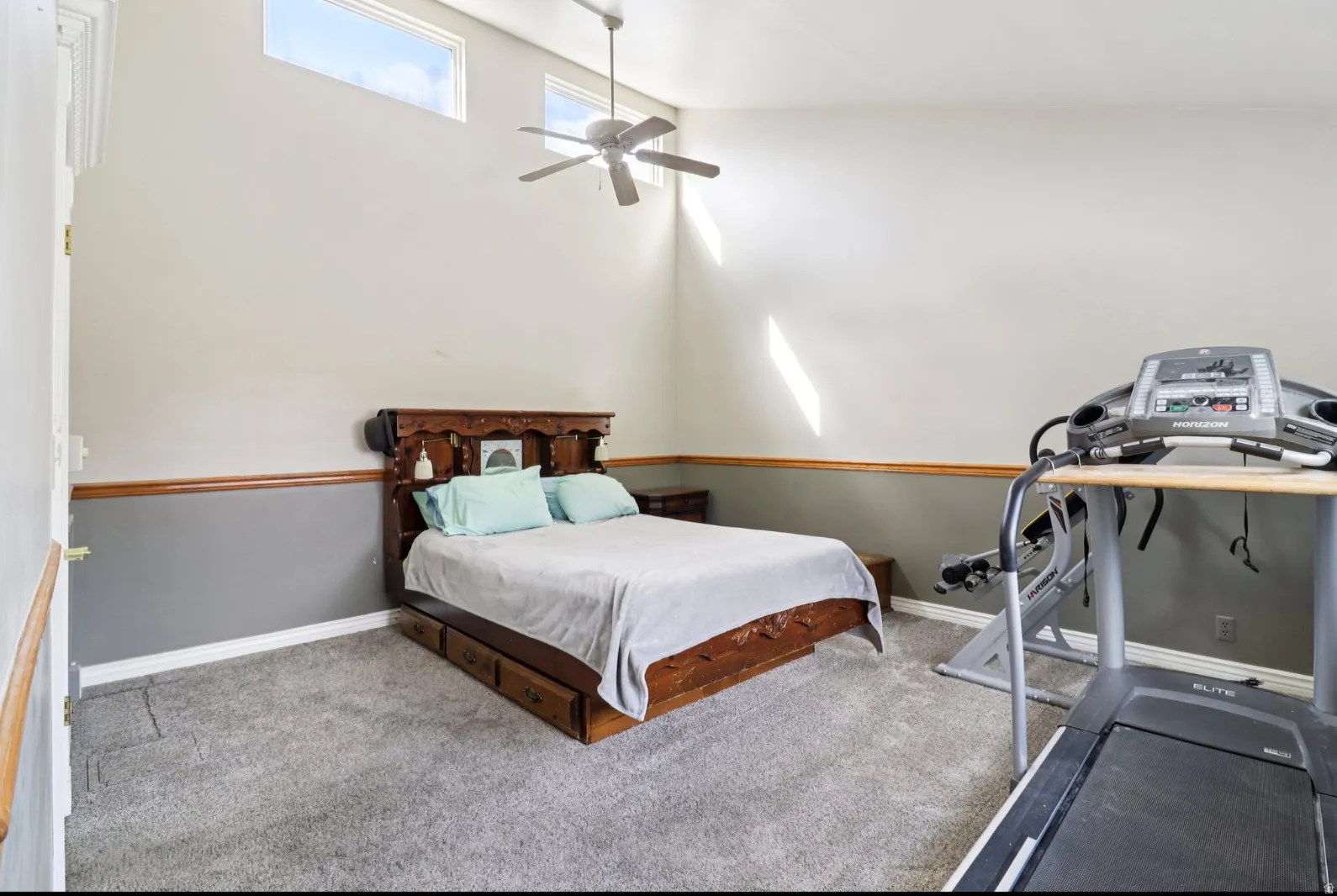 Carpeted bedroom featuring a ceiling fan and baseboards