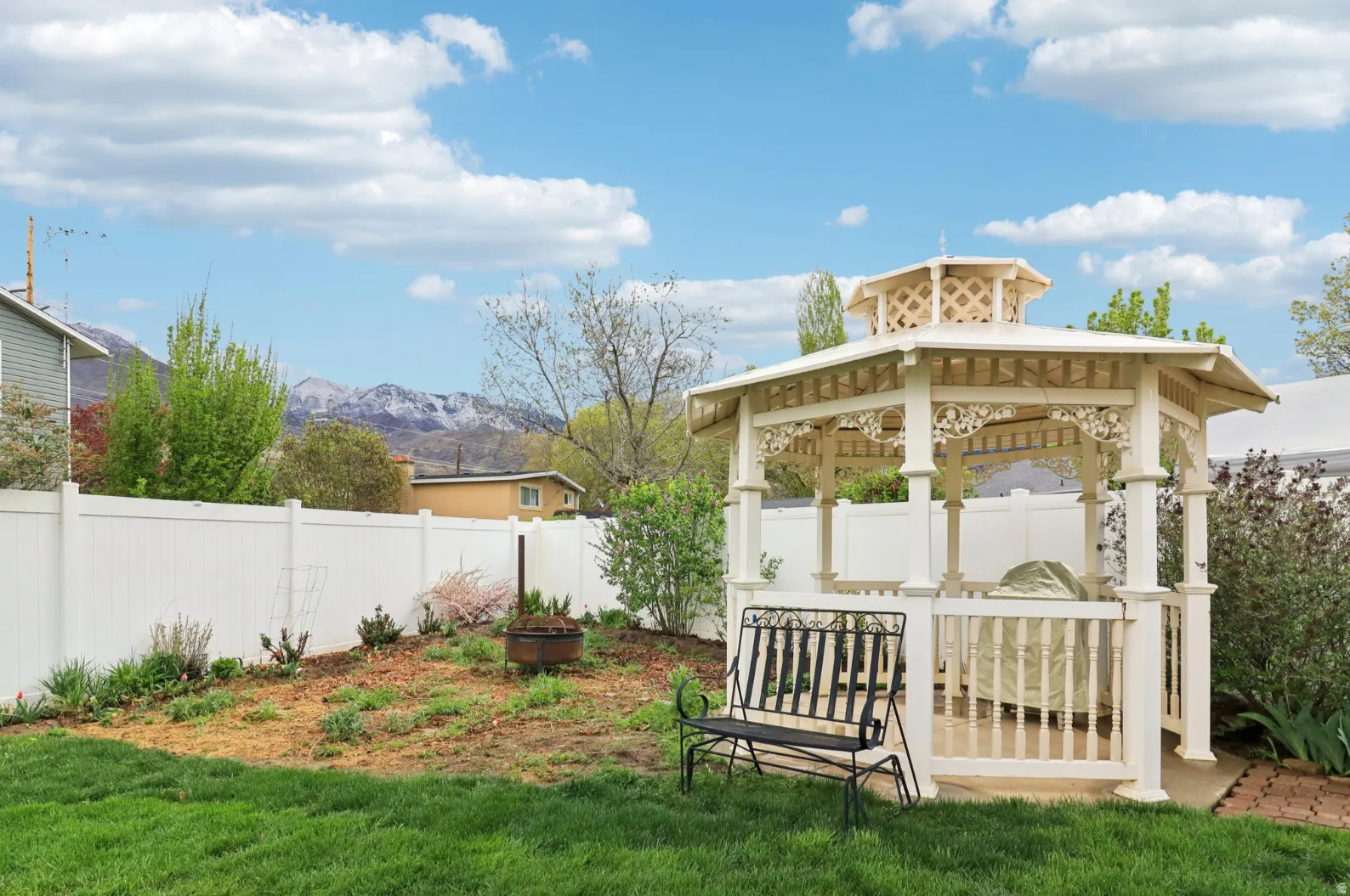 Fenced backyard featuring a gazebo, a mountain view, and a patio area