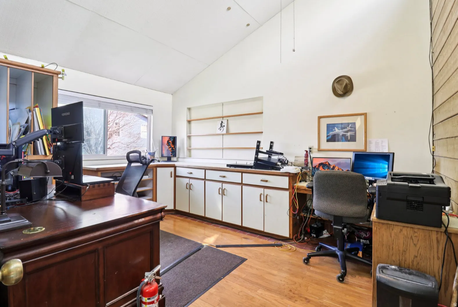 Office space with light wood finished floors and vaulted ceiling