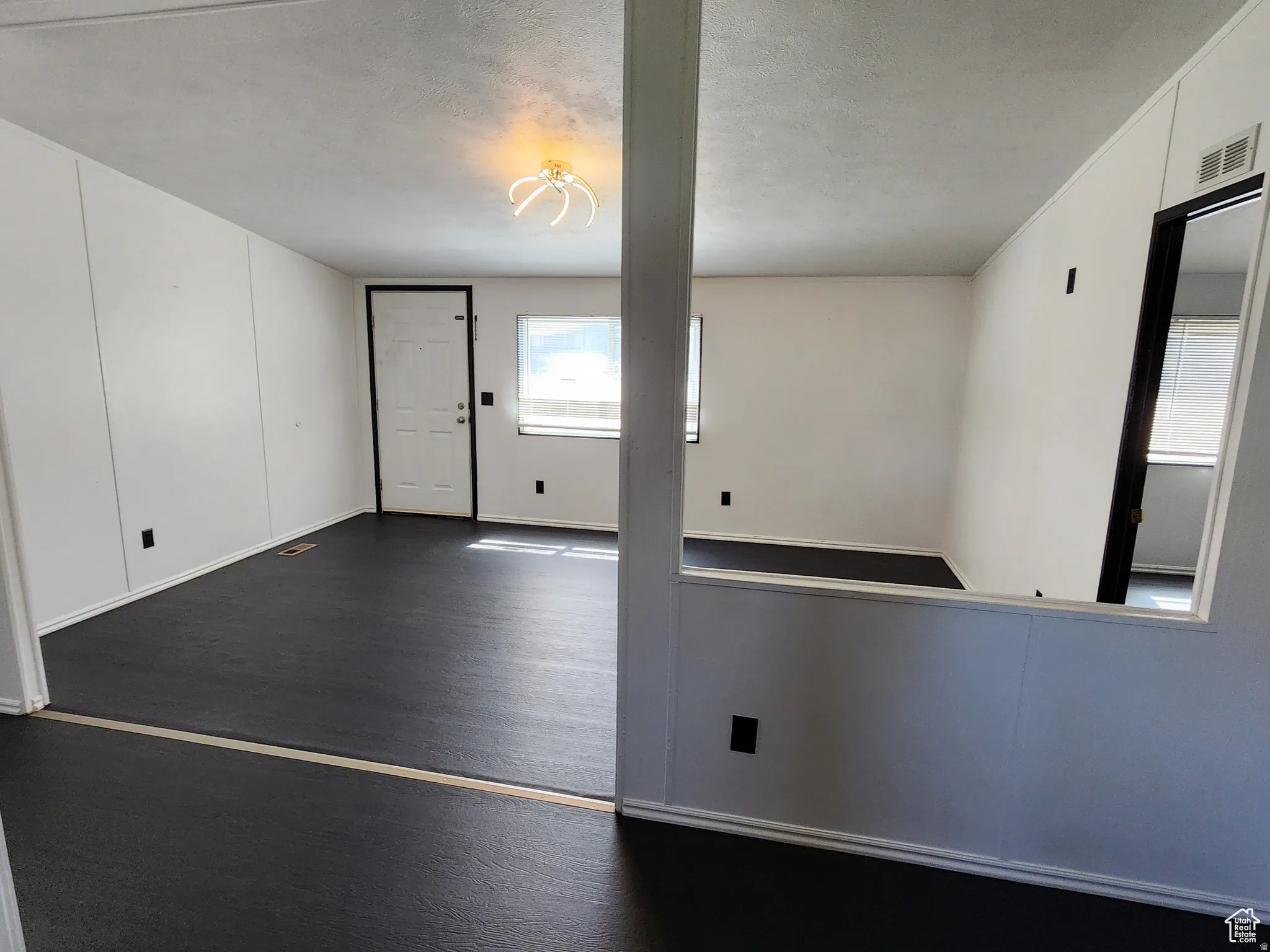 Spare room with dark wood-style flooring and a textured ceiling
