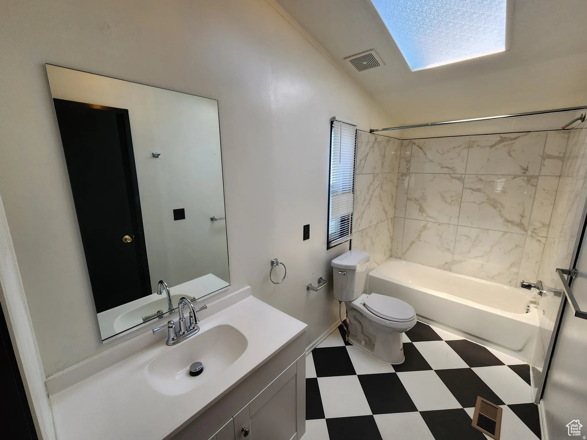 Full bathroom with vanity, light floors,  shower combination, and lofted ceiling