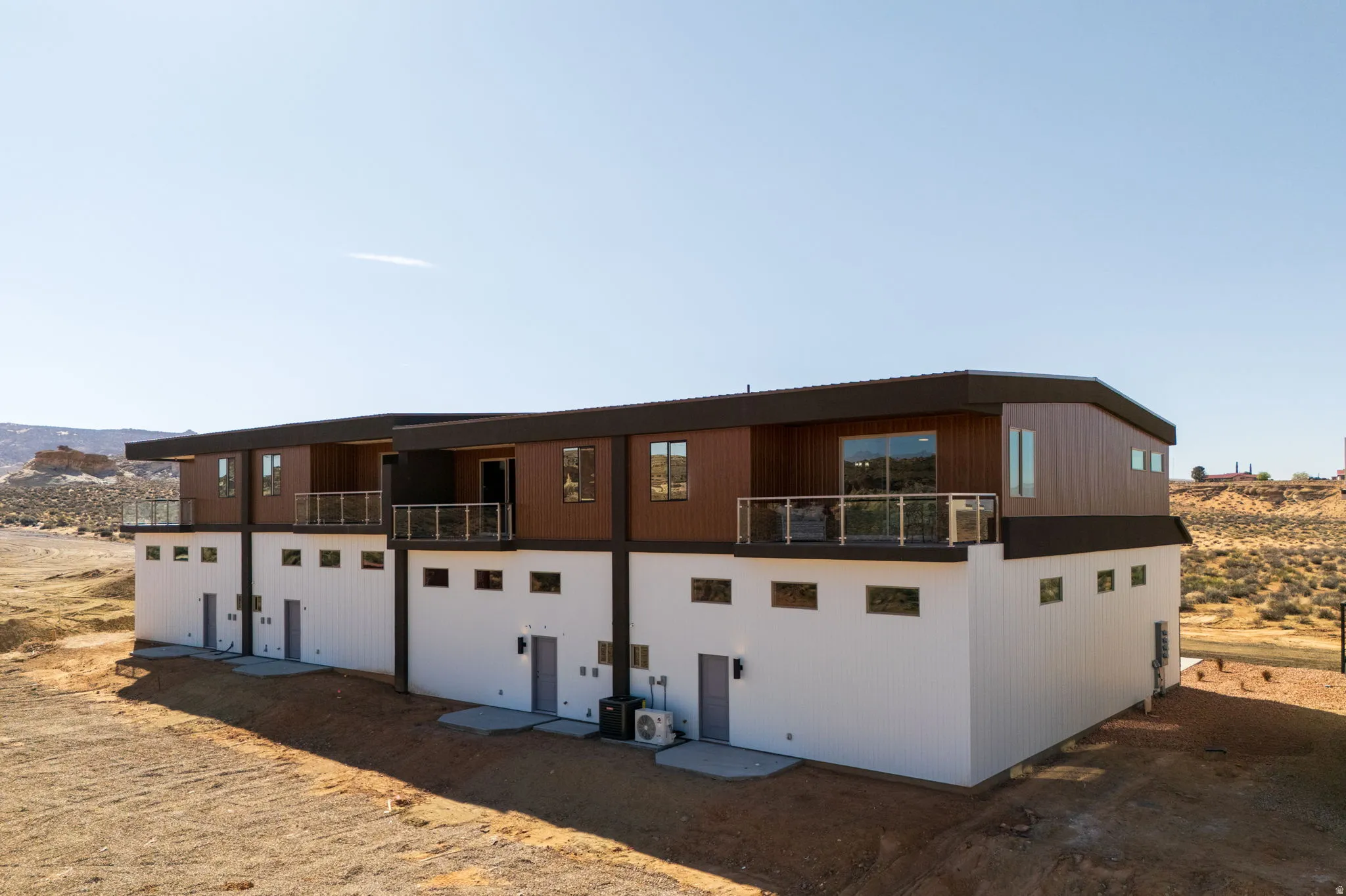 Back of house with a balcony and a mountain view