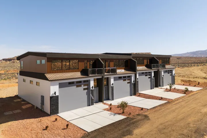 View of front facade featuring driveway, a mountain view, a metal roof, and an attached garage