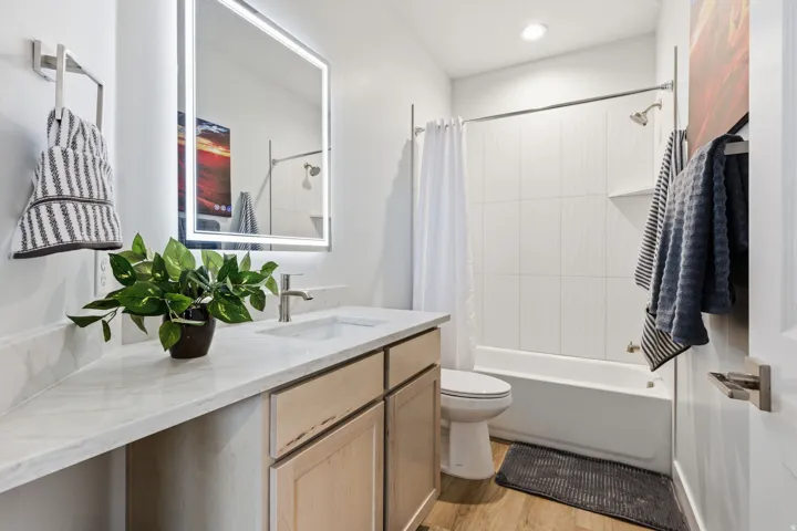 Bathroom with vanity, light wood-style flooring, and shower / tub combo with curtain