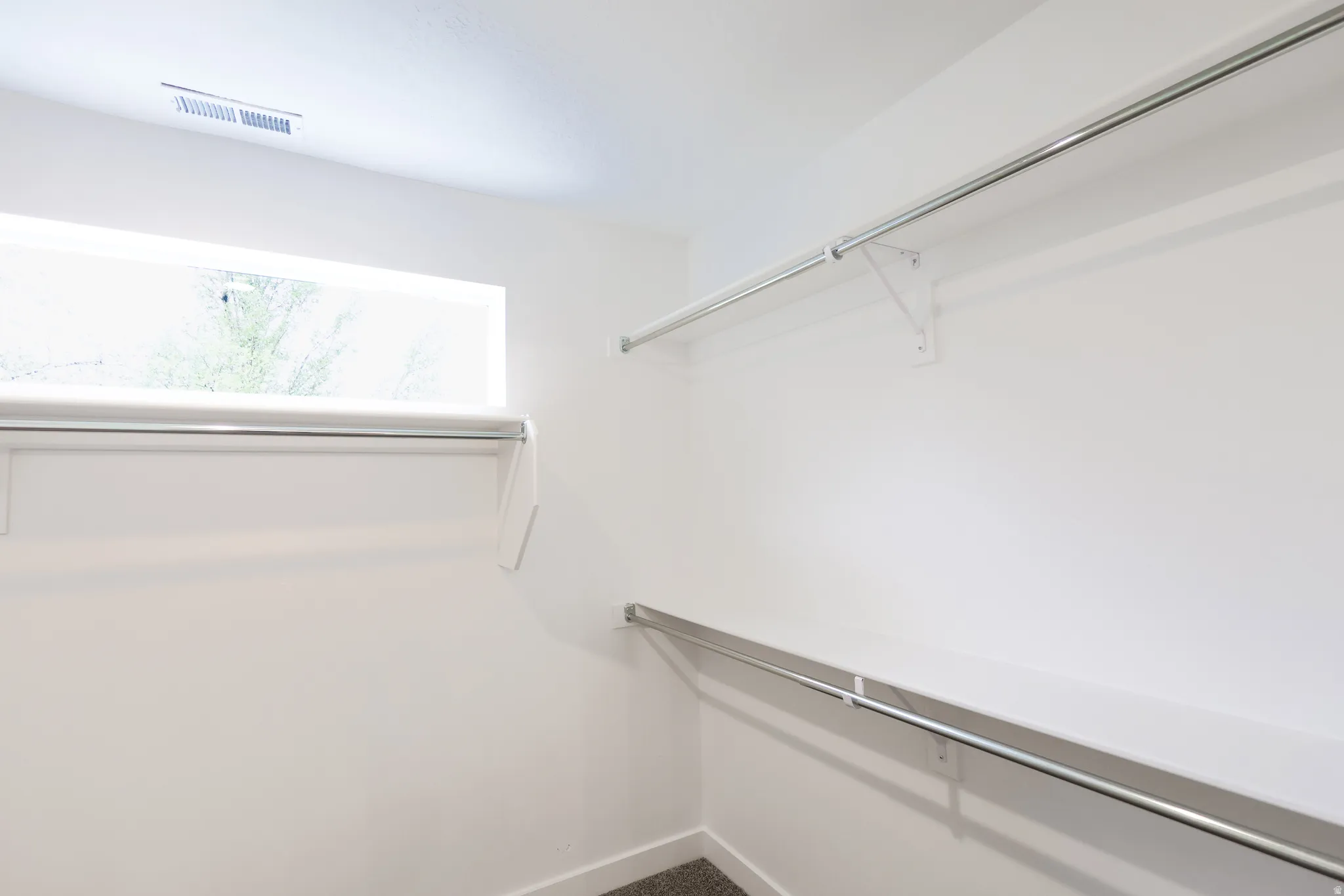 Walk in closet featuring dark carpet