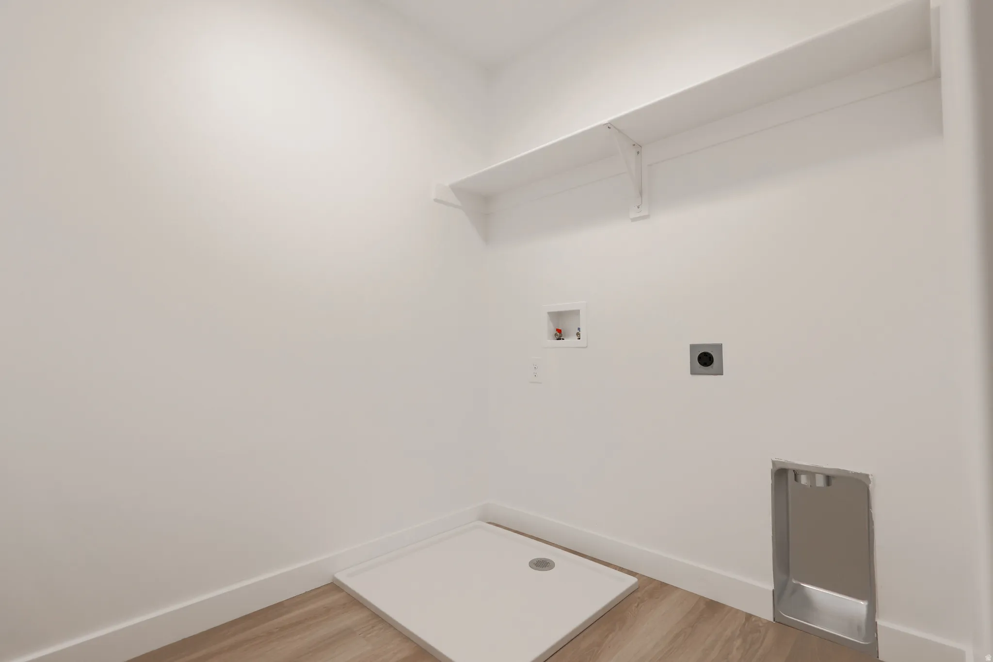 Laundry room featuring washer hookup, light wood-type flooring, and hookup for an electric dryer