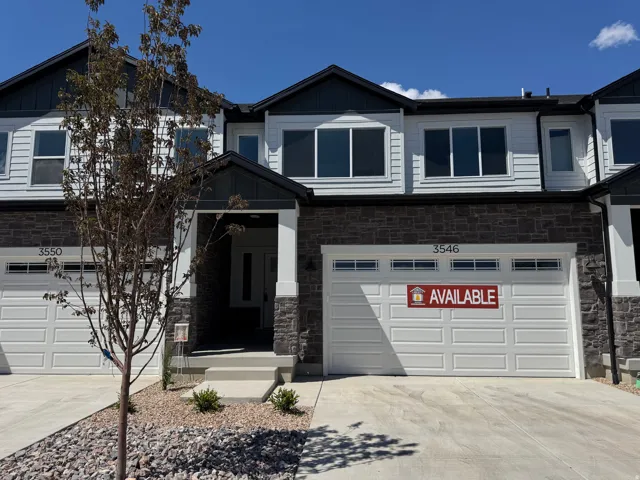 Modern townhome exterior featuring stone accents and light-colored siding
