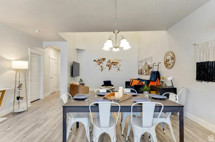 Dining space with hanging lights and light wood finished floors