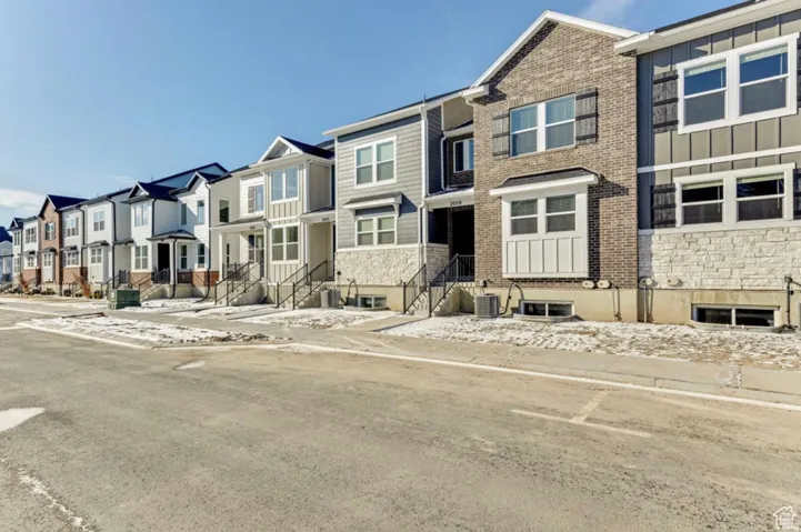View of front of house featuring stone siding, a residential view, and board and batten siding