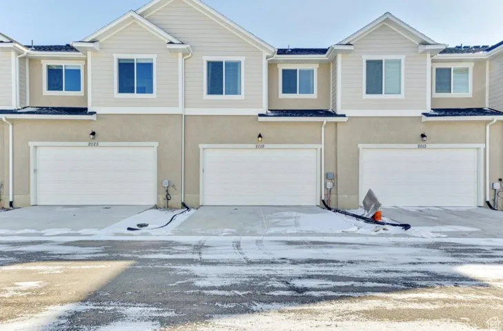 View of front of house with stucco siding, a garage, and concrete driveway