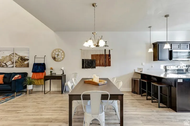 Dining room with hanging lights and light wood-style floors