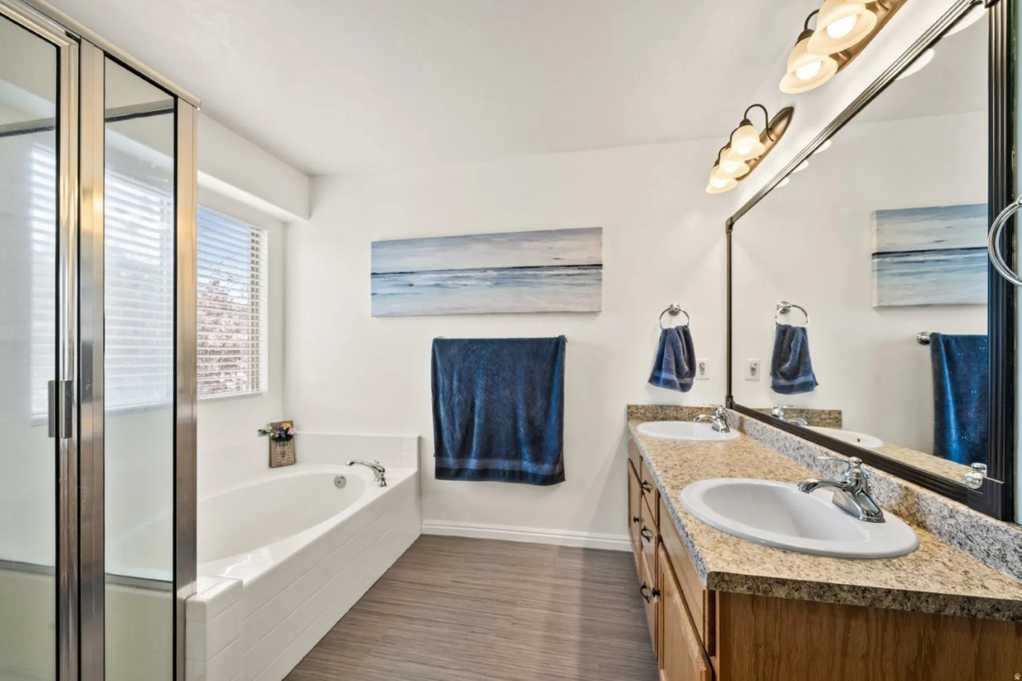 Bathroom featuring double vanity, a bath, and a stall shower