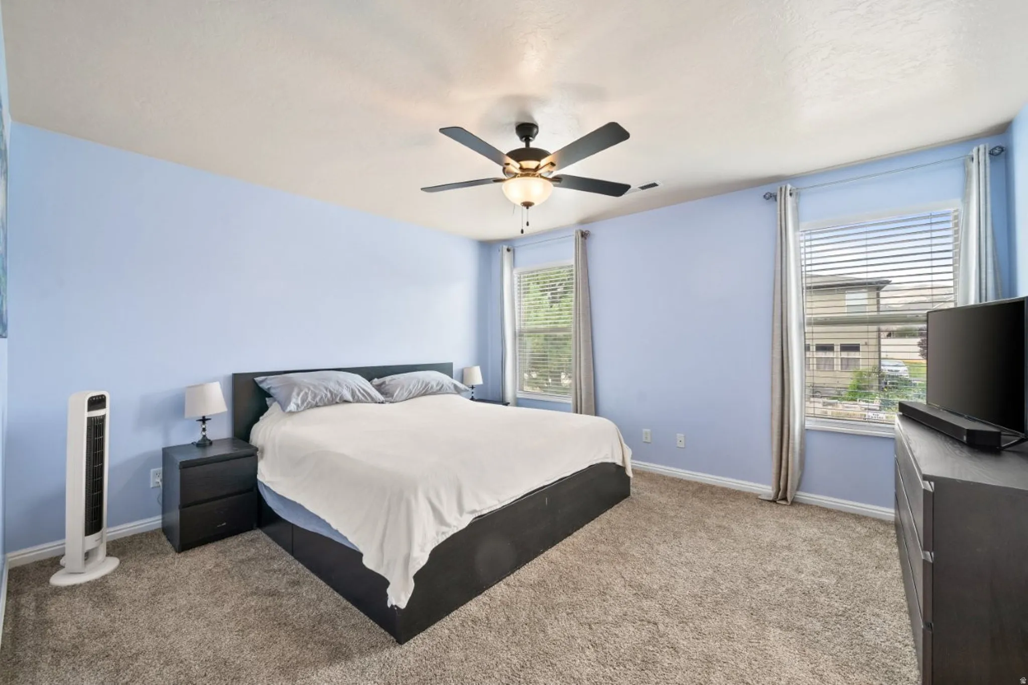Bedroom featuring light carpet and a ceiling fan