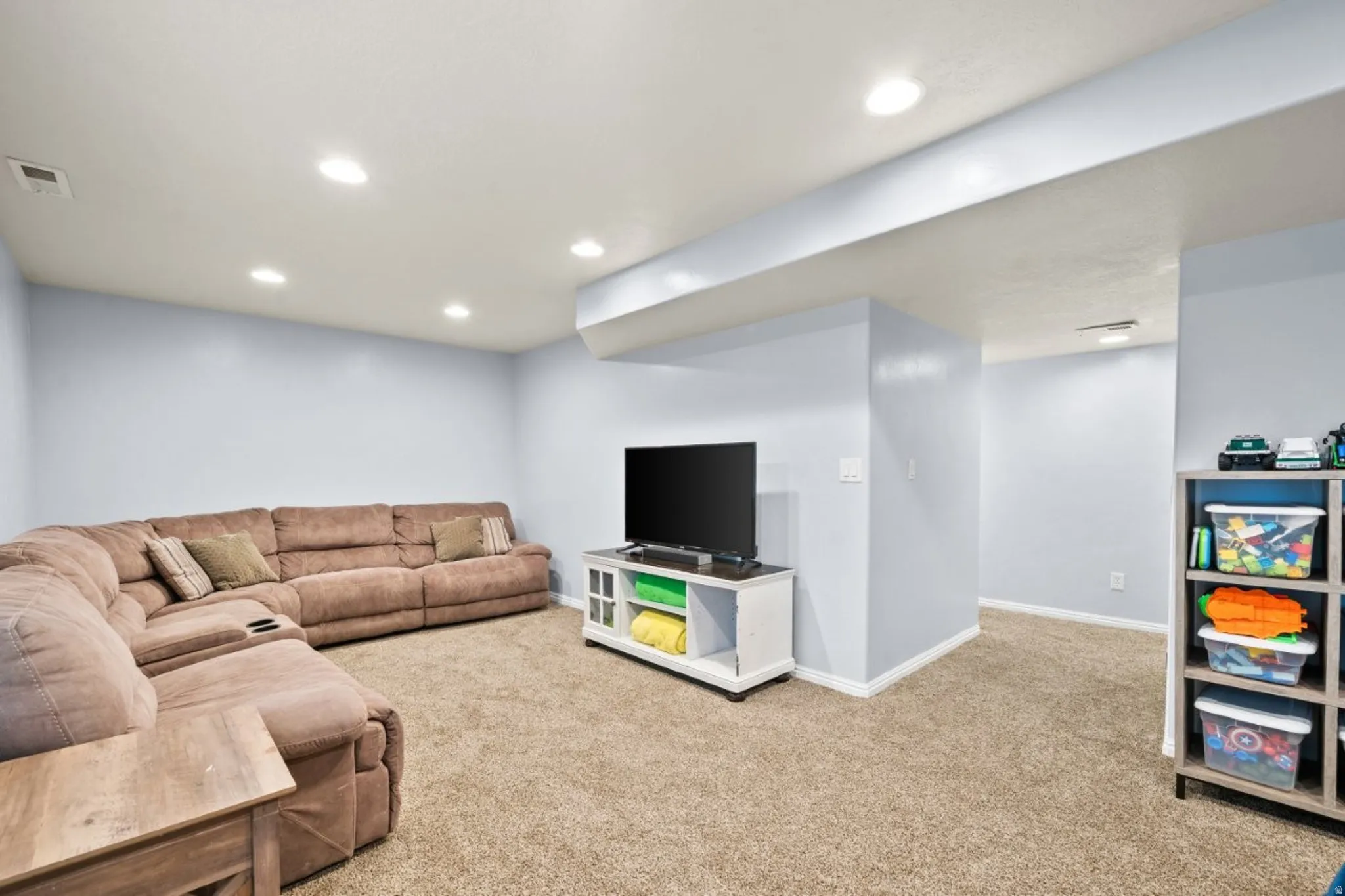 Living room with light colored carpet and recessed lighting