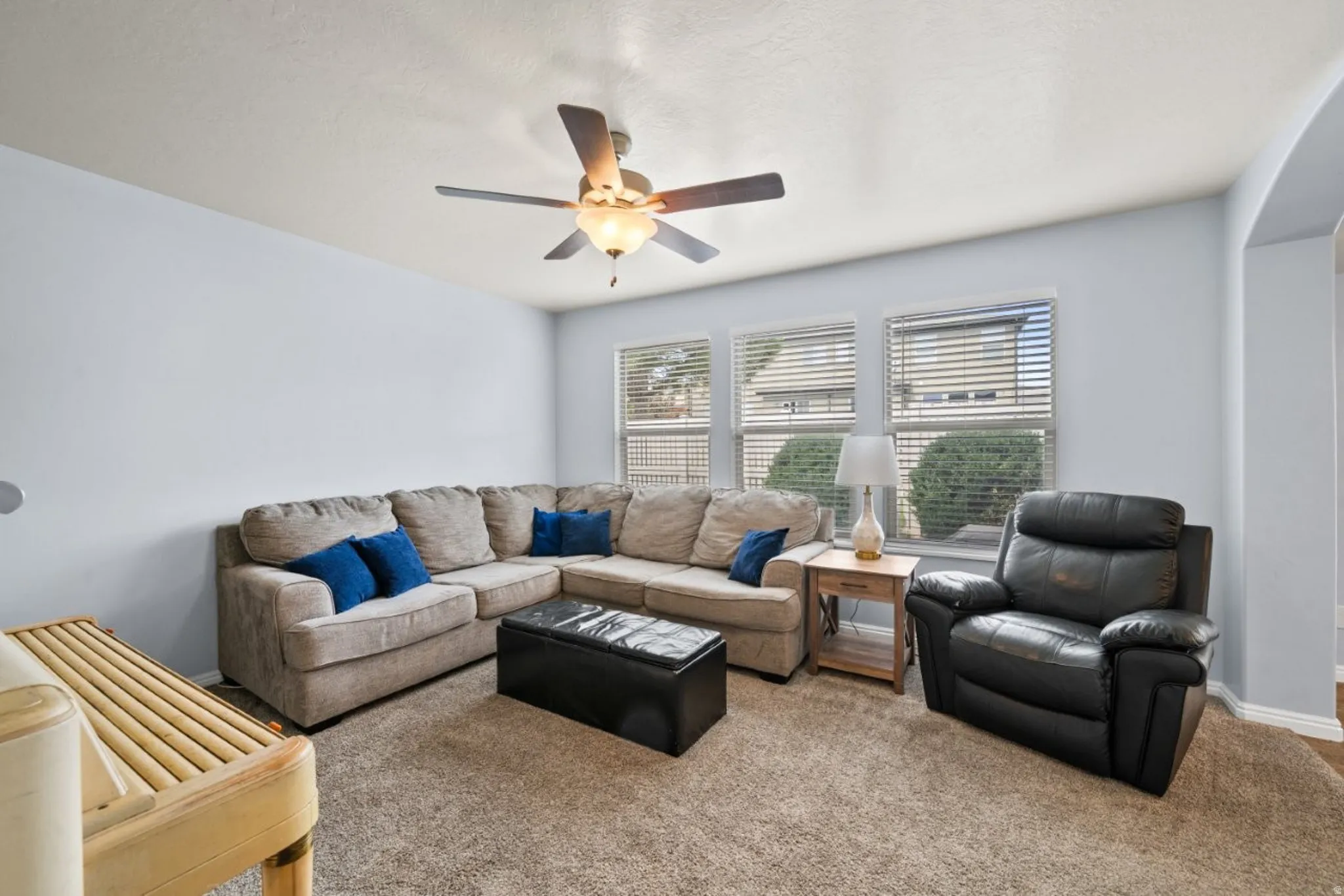 Living area with carpet floors and ceiling fan