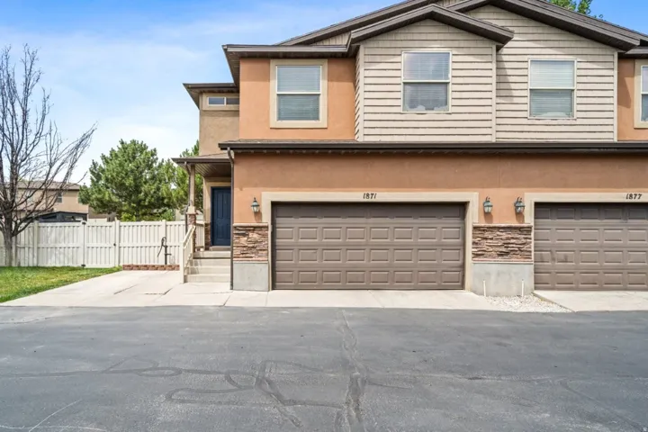 View of front of property with stone siding, stucco siding, and a gate