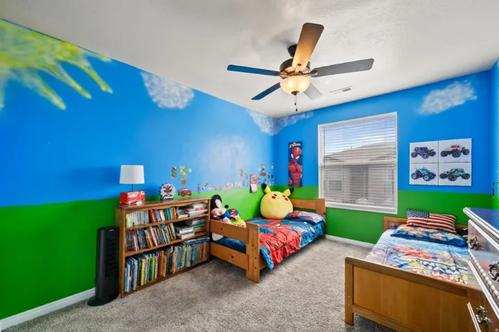 Carpeted bedroom featuring baseboards and ceiling fan