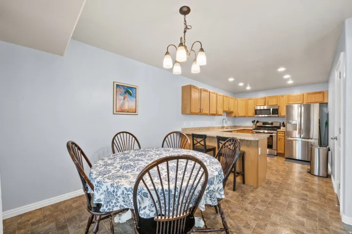 Dining space with stone finish floors and a chandelier