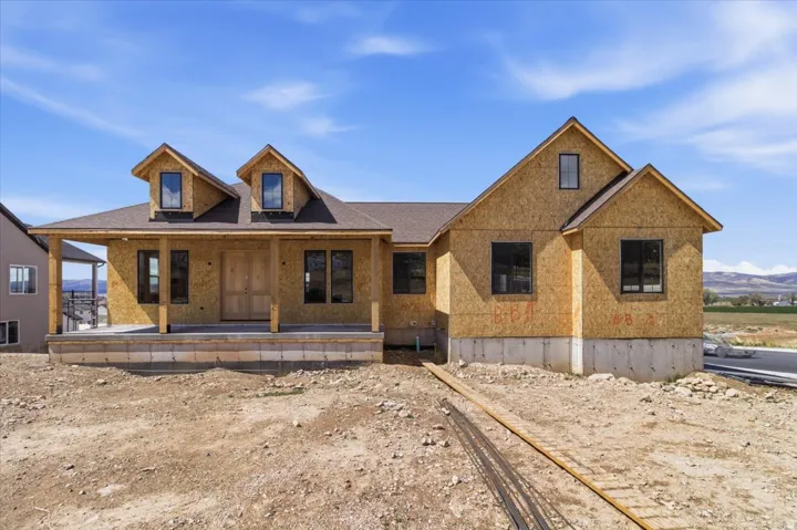 View of front of property with covered porch and roof with shingles