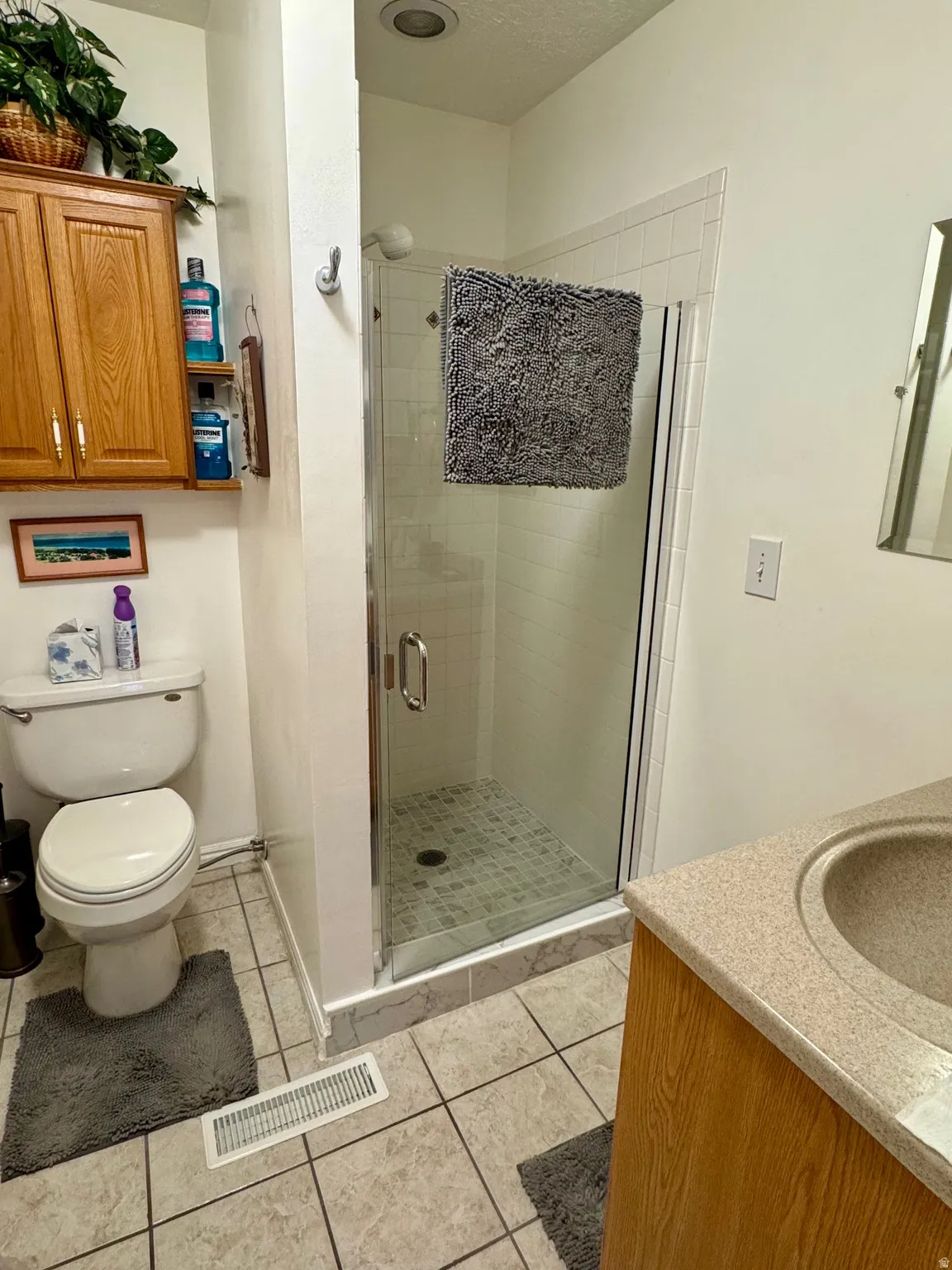 Bathroom featuring vanity, a shower stall, and light tile patterned floors