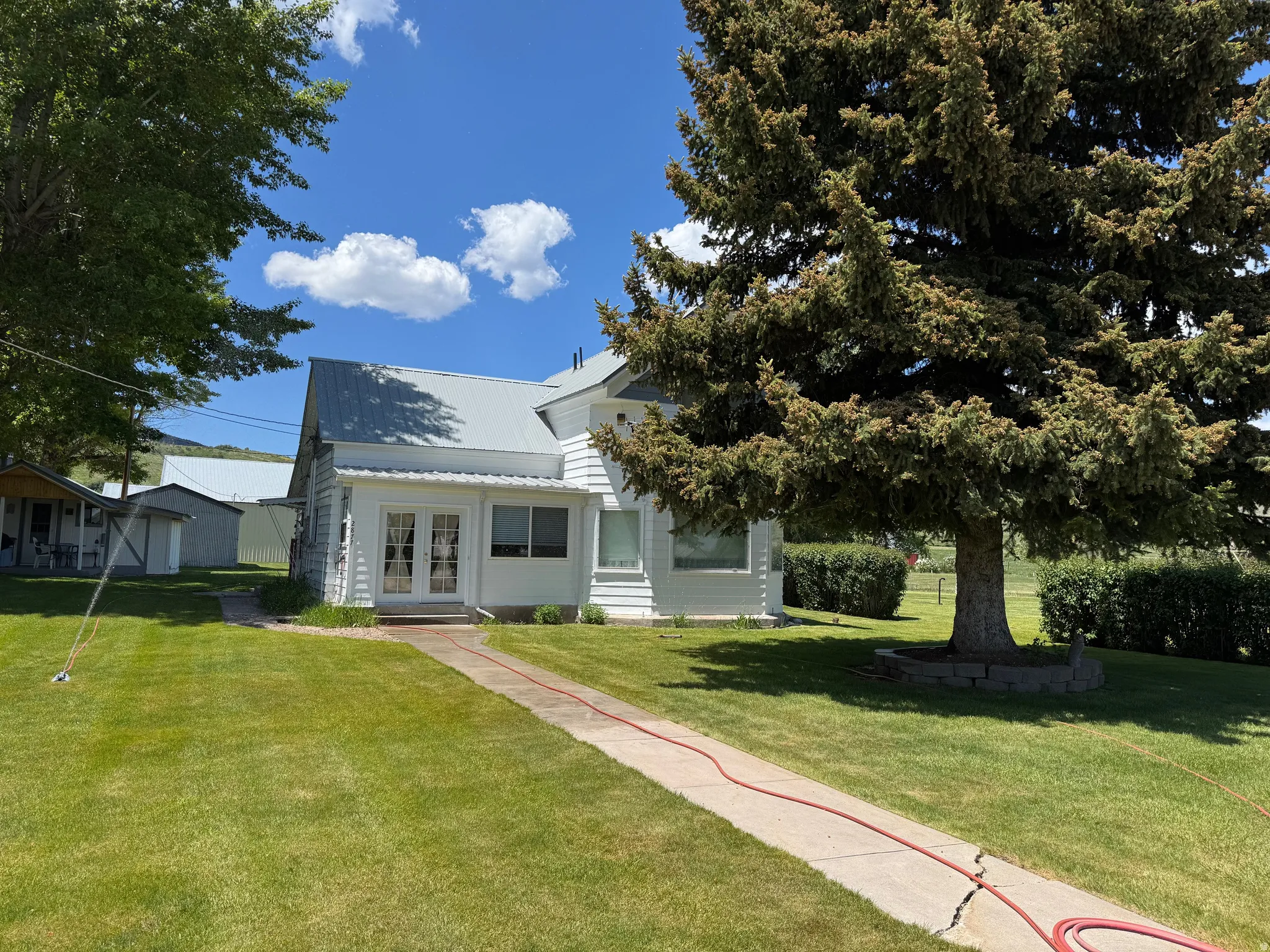 View of front of house featuring french doors, a front lawn, and a metal roof