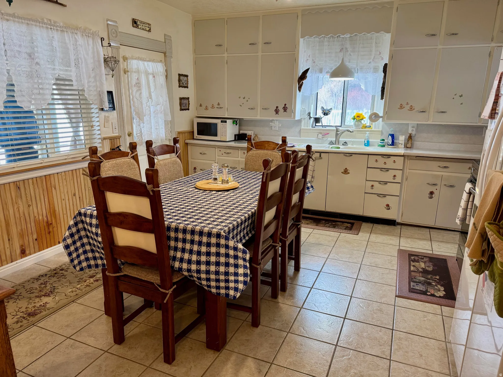 Dining room featuring wood walls, wainscoting, and light tile patterned floors