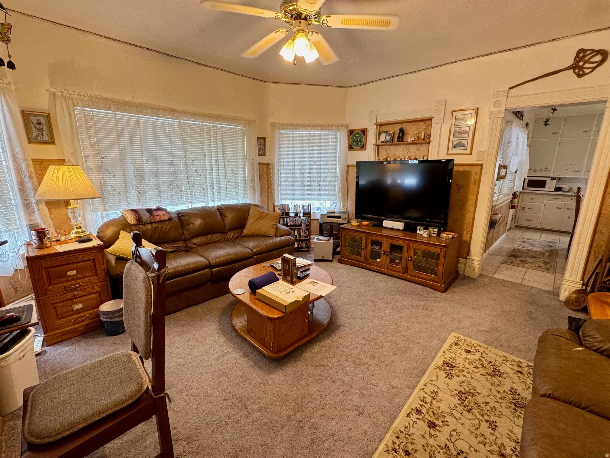 Living room featuring a ceiling fan and light colored carpet
