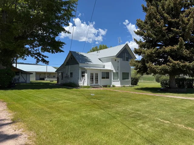 View of front of home featuring a front yard, a metal roof, and entry steps