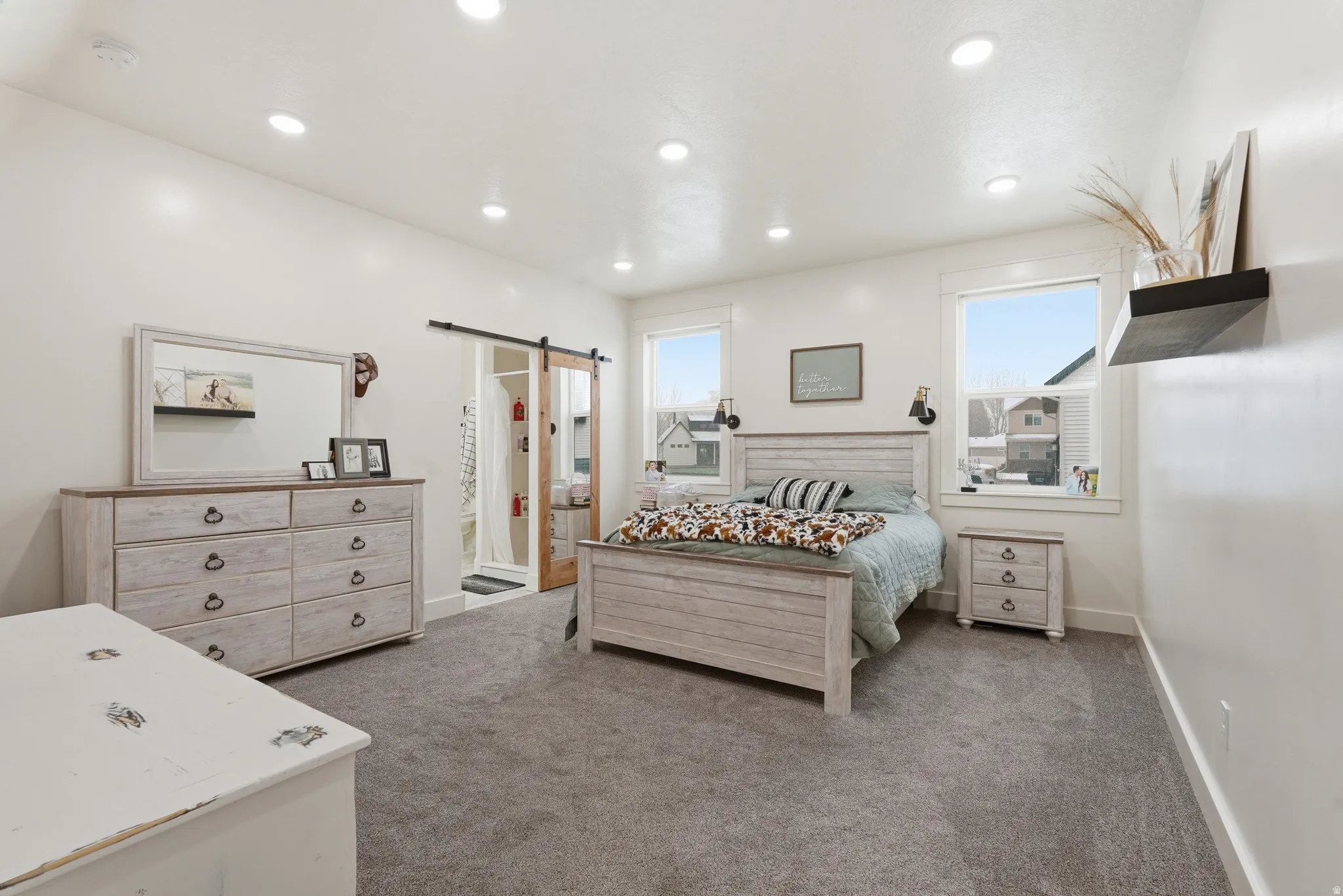 Bedroom featuring dark carpet, a barn door, multiple windows, and recessed lighting