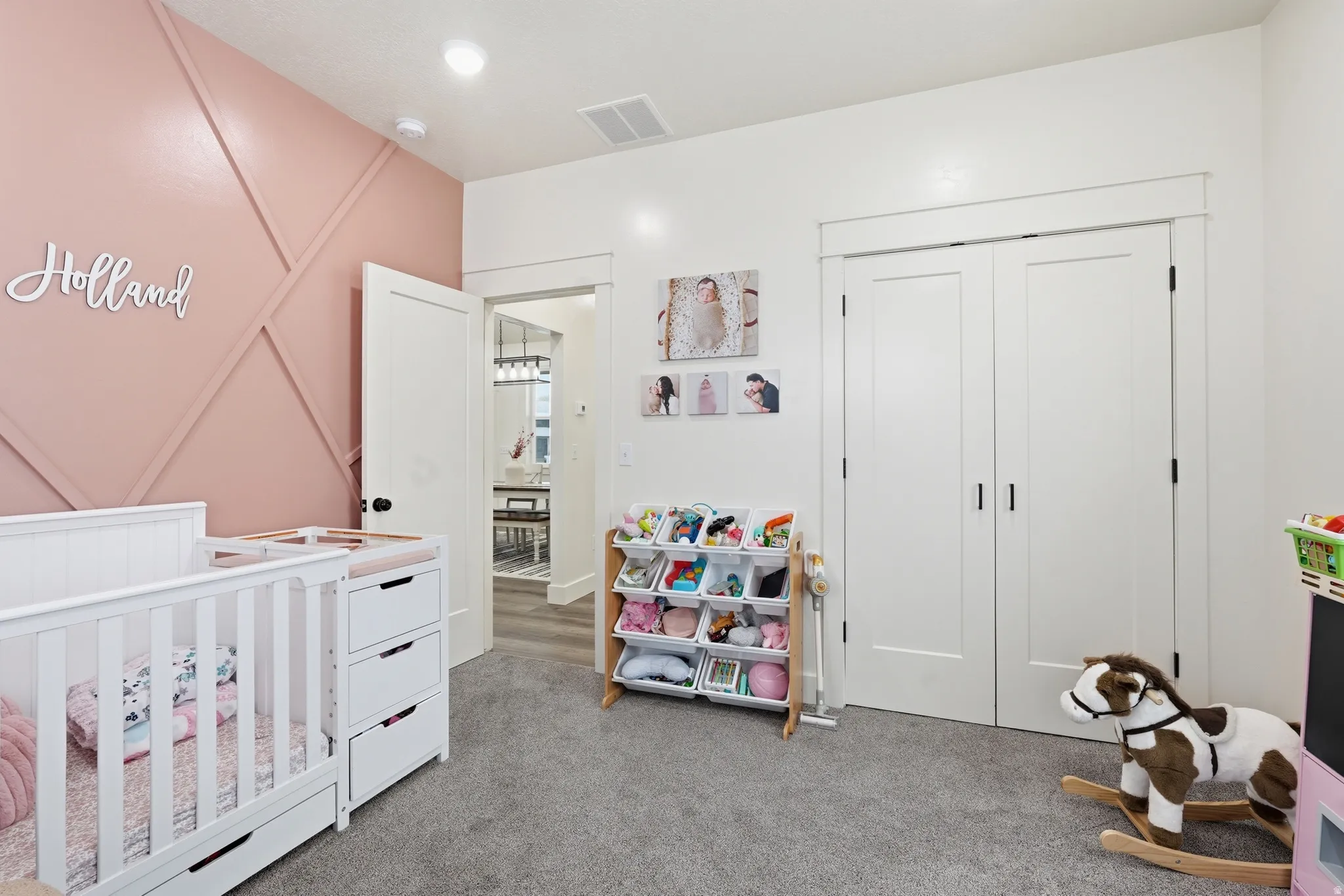 Bedroom with a crib, light carpet, and a closet