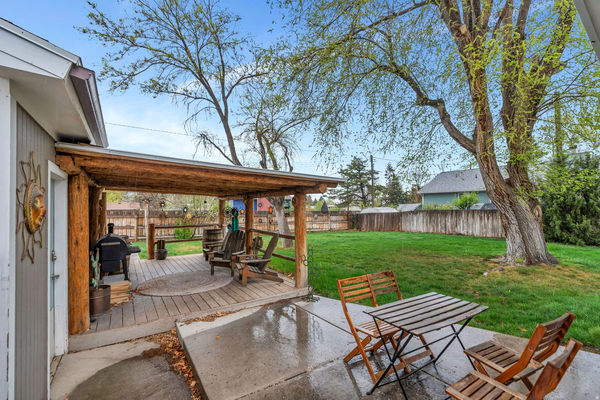 Fenced backyard with a wooden deck and a grill