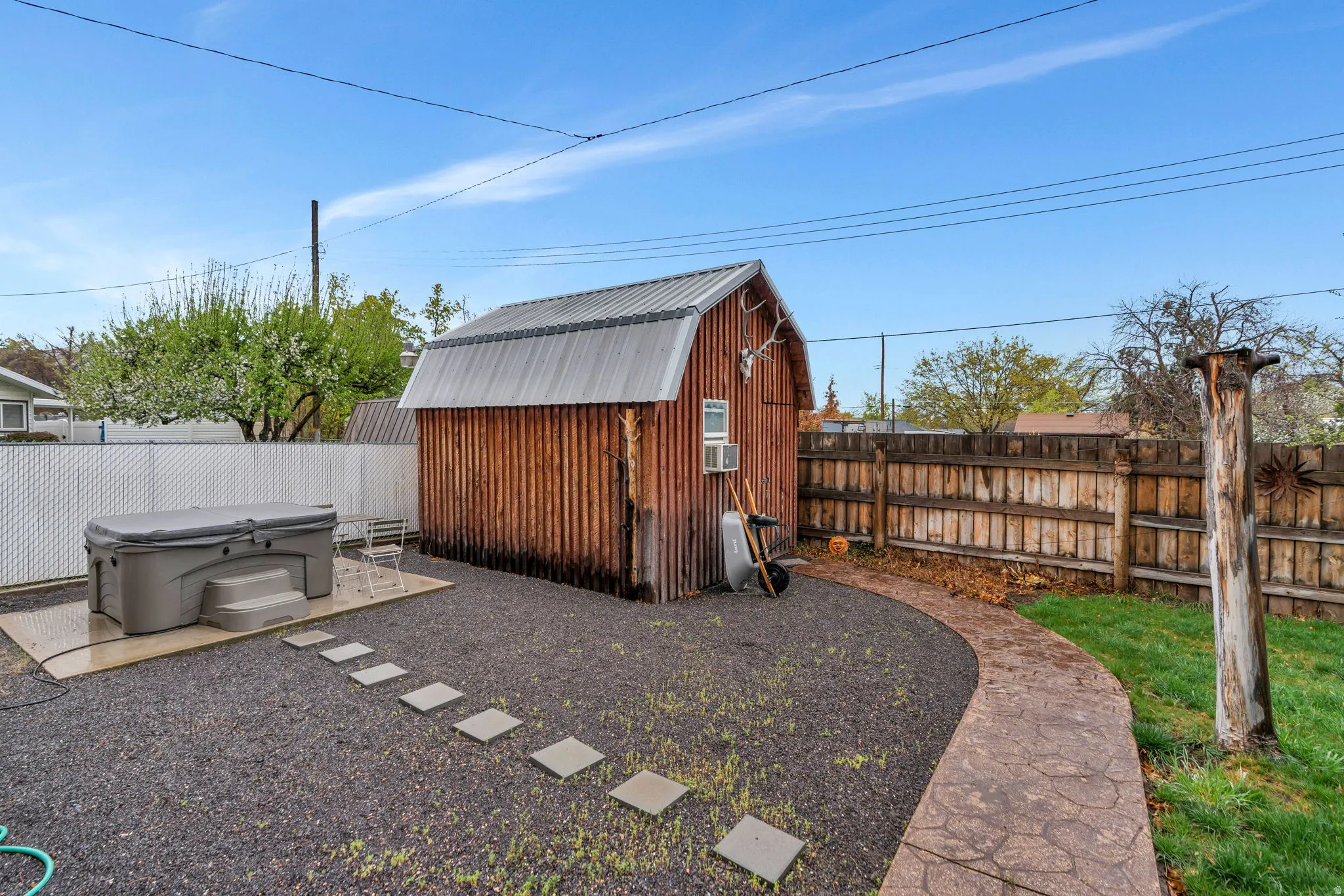 View of shed featuring a fenced backyard and a hot tub