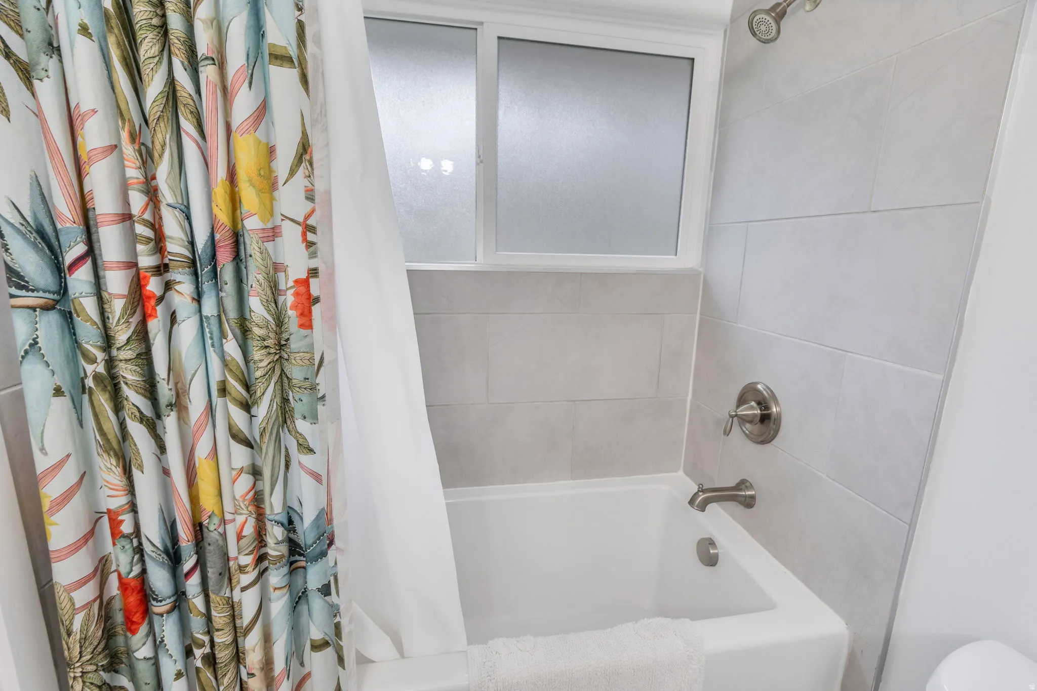 Full bathroom featuring shower / bathtub combination with curtain and toilet