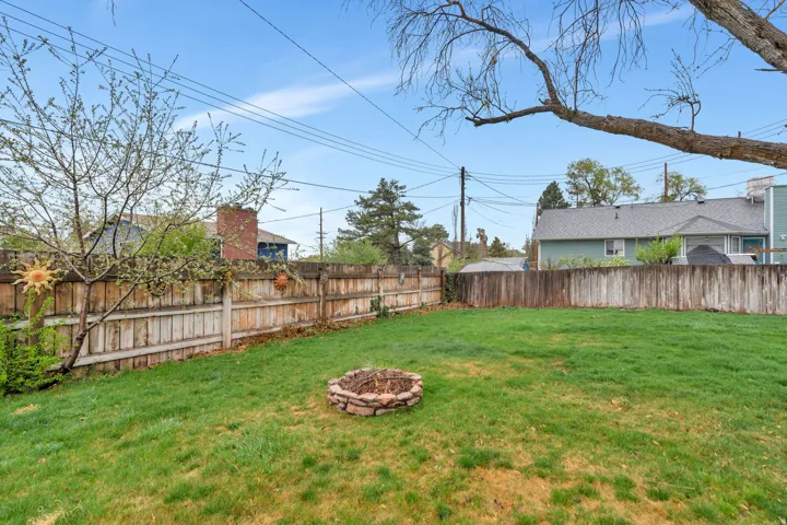 Fenced backyard with an outdoor fire pit