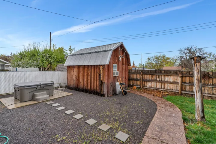 View of shed featuring a fenced backyard and a hot tub