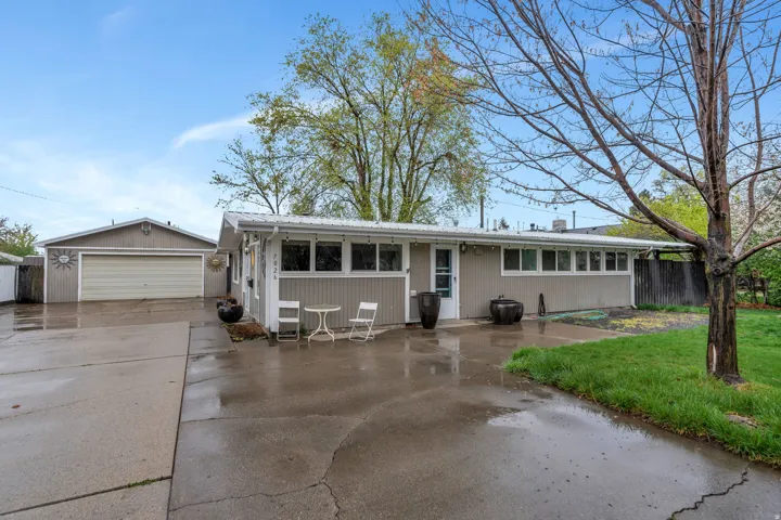 Single story home featuring a garage, a metal roof, and a patio area