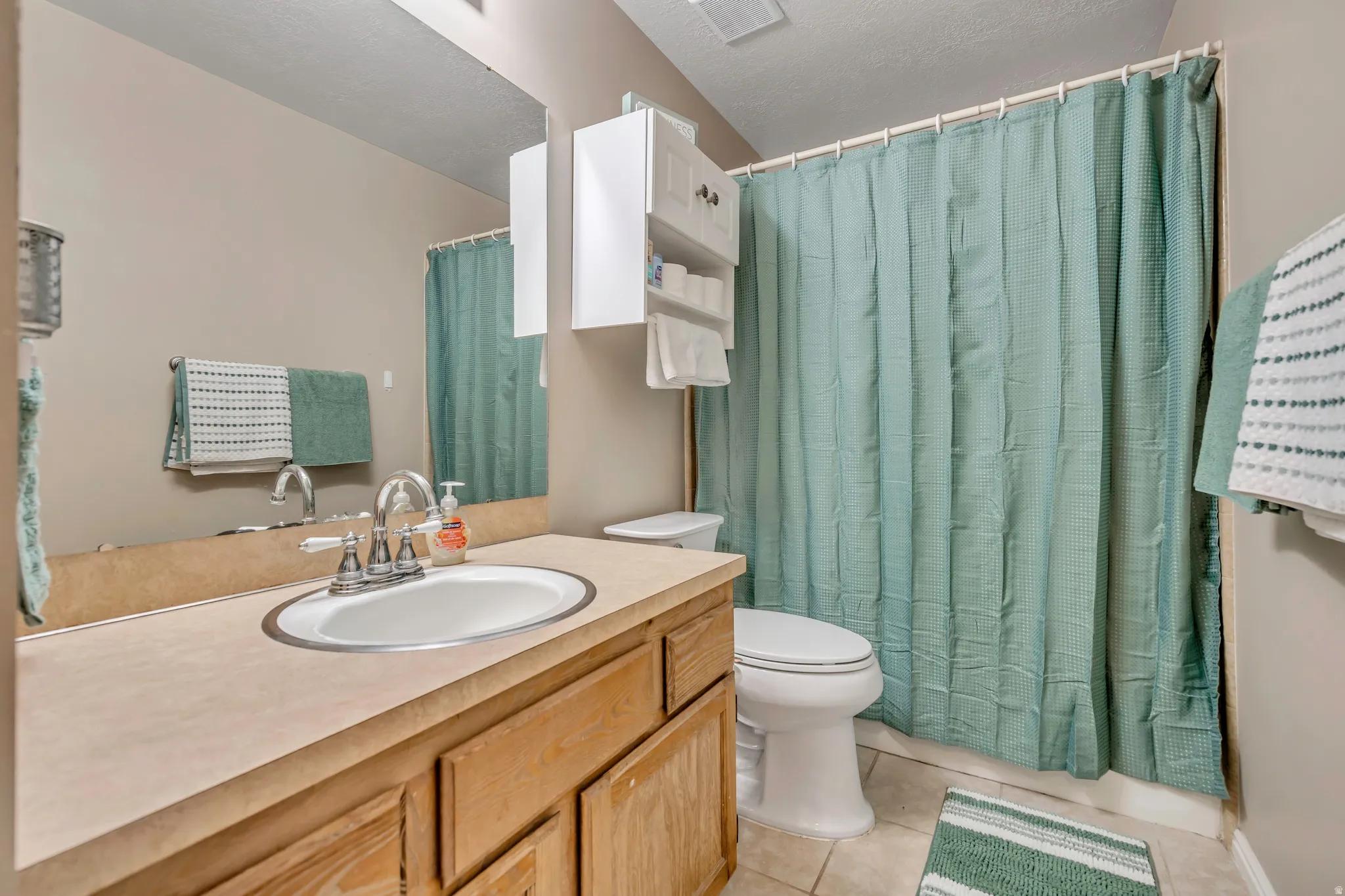 Full bathroom with vanity and light tile patterned floors