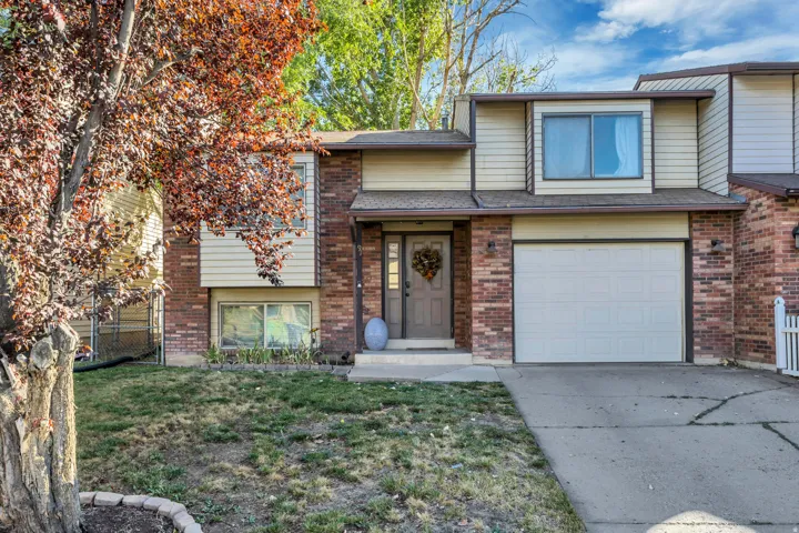 Tri-level home with brick siding, concrete driveway, and an attached garage
