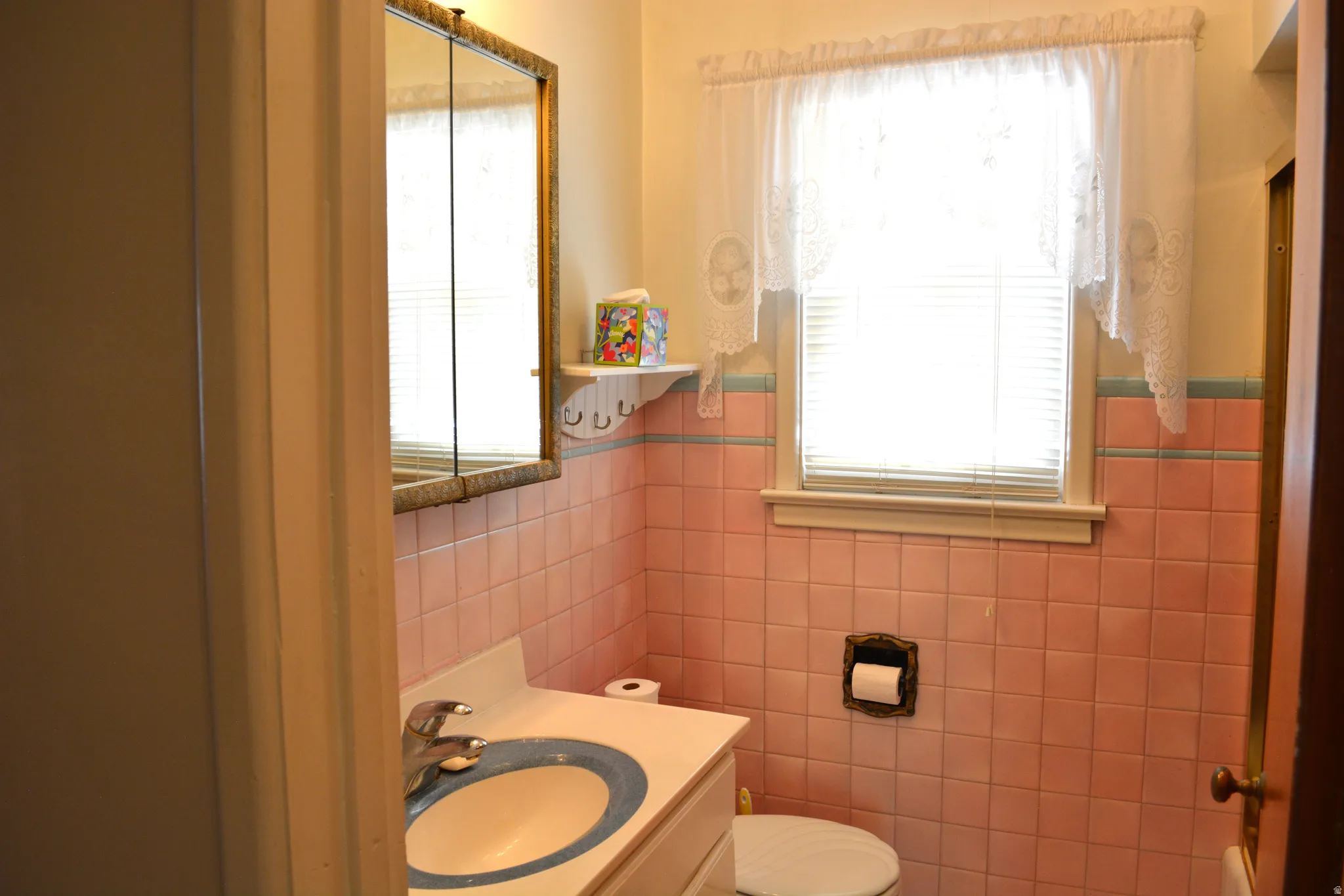 Bathroom with vanity, plenty of natural light, and tile walls