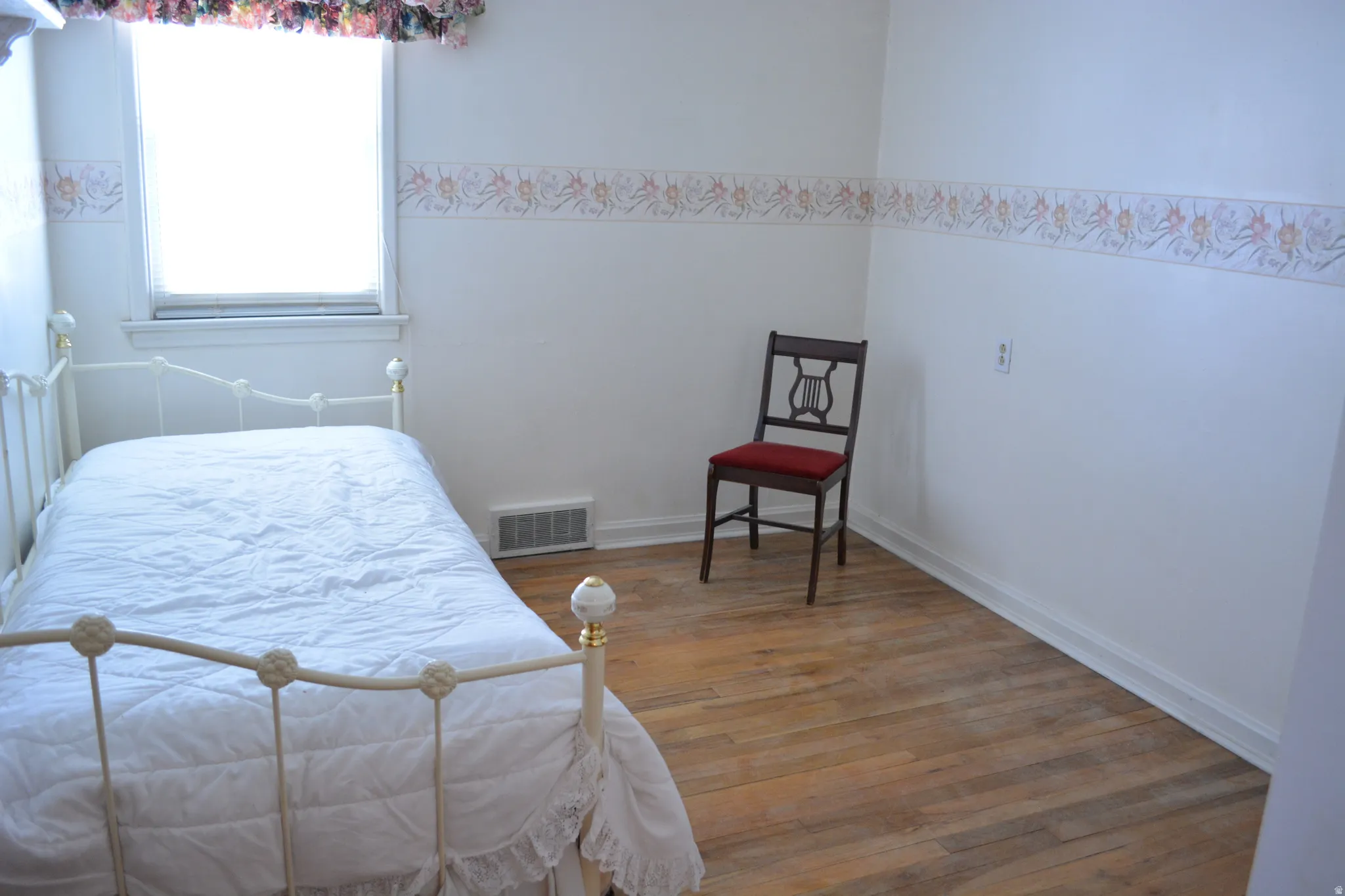 Bedroom featuring wood finished floors and baseboards