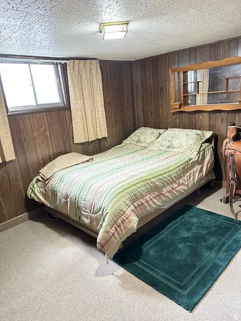 Bedroom with wood walls and carpet floors