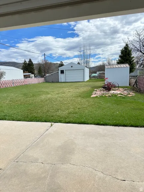 View of yard featuring an outbuilding, a detached garage, and a patio