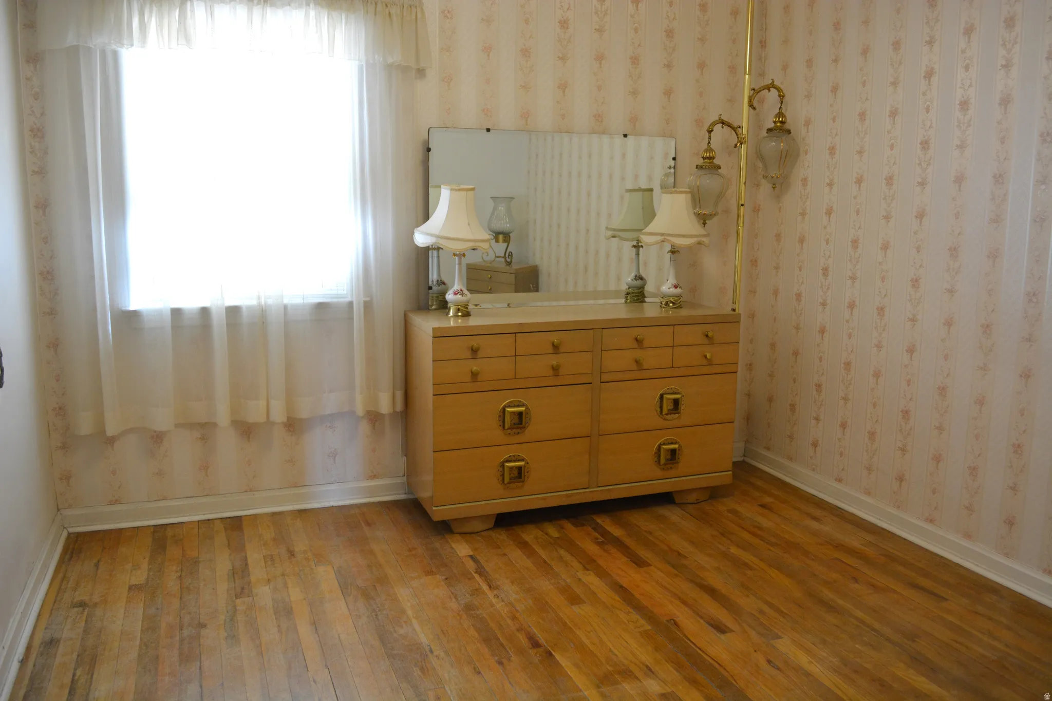 Bedroom featuring light wood finished floors and wallpapered walls