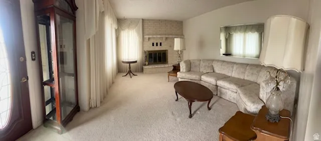Living room with light colored carpet and a brick fireplace