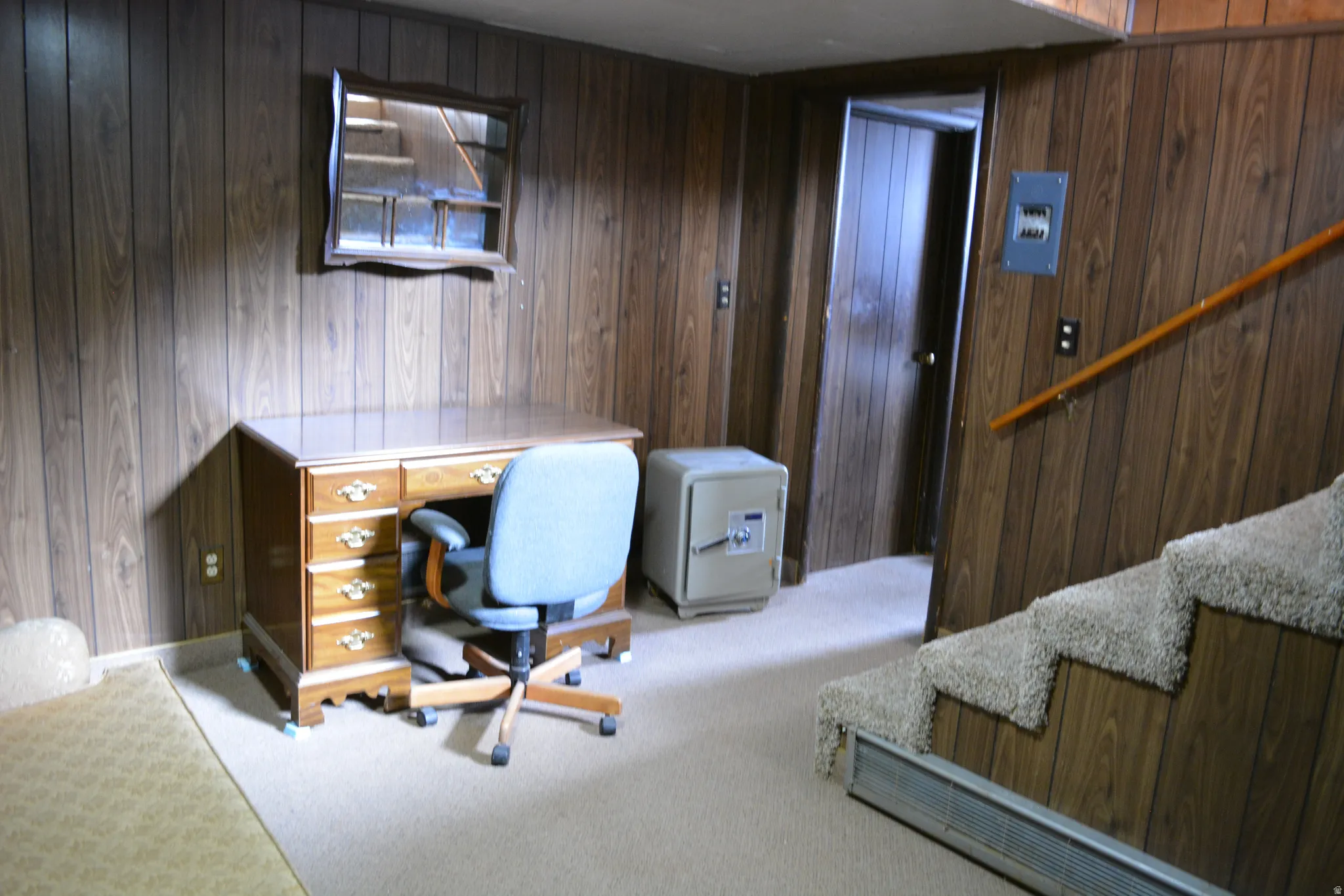 Office area featuring light carpet and wood walls