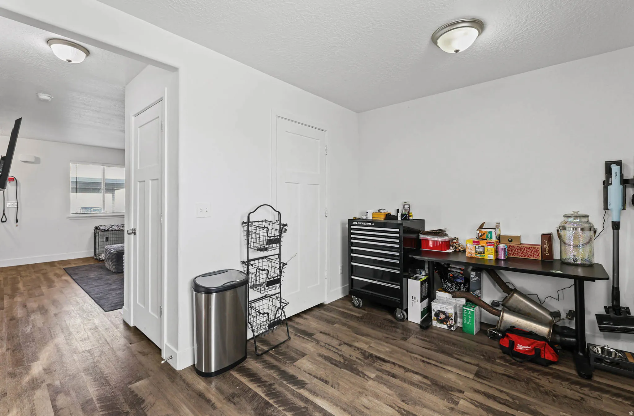 Miscellaneous room with dark wood-style floors and a textured ceiling