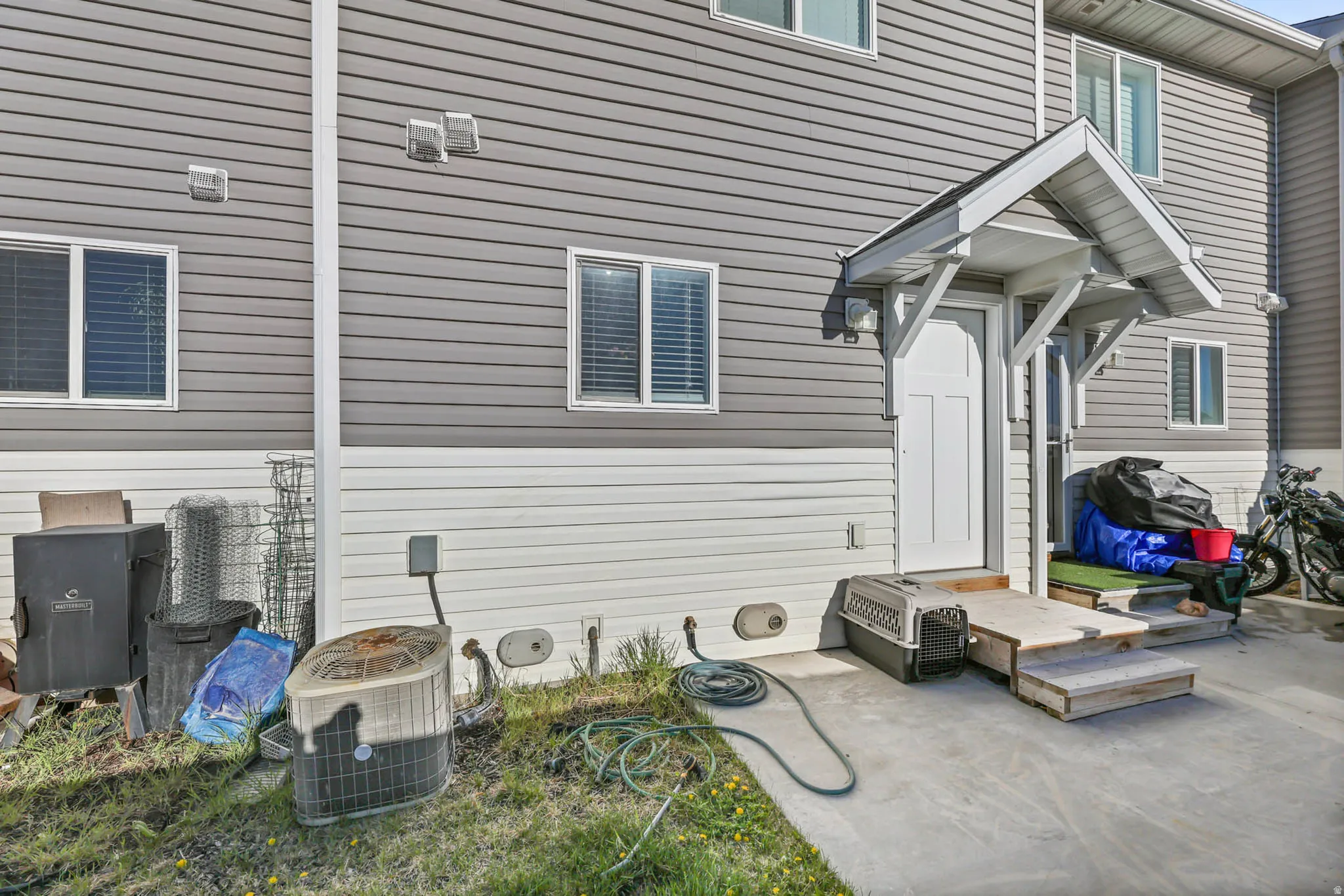 View of side of property featuring a central air condition unit and a patio area