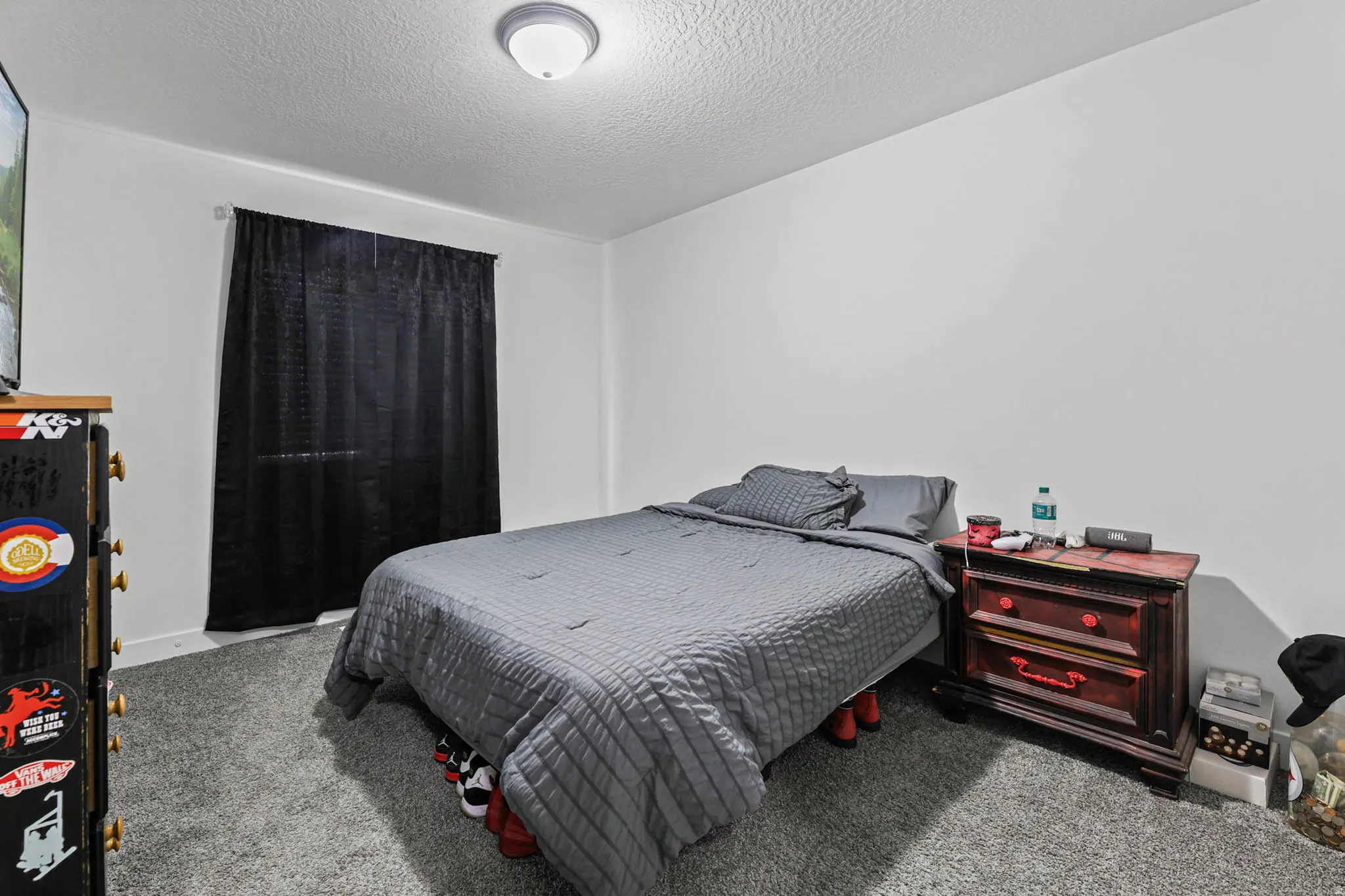 Bedroom with light carpet and a textured ceiling