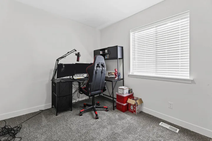 Office area featuring light carpet and baseboards